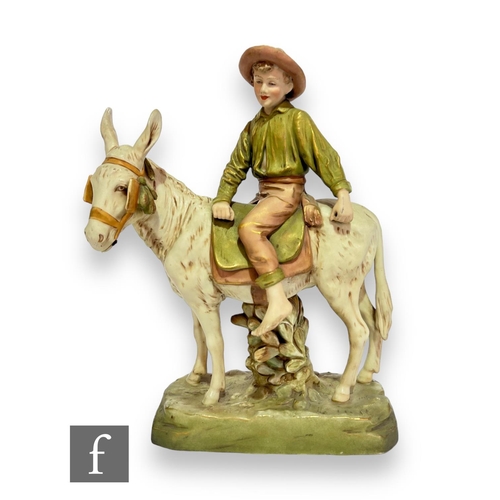 102 - A large late 19th to early 20th Century Royal Dux figure group modelled as a young boy riding a donk... 