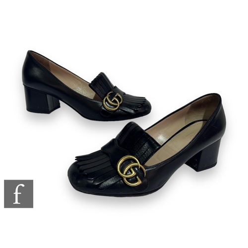 189 - A pair of Gucci black leather mid heel loafers, with black fringe details and overlapping GG in gold... 