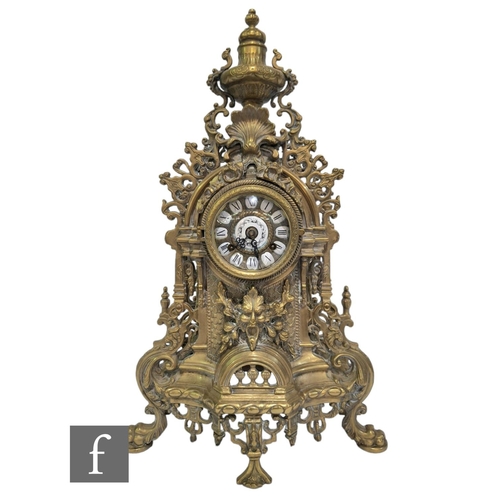 367 - A late 20th Century Louis XIV style gilt mantle clock, surmounted with an urn over a dial, on mask s... 