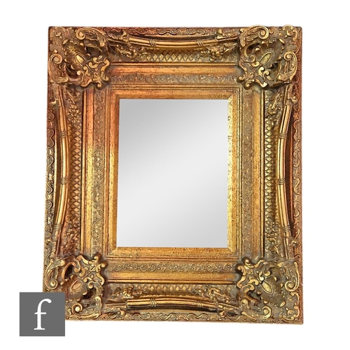 568 - A 20th Century replica gilt bevelled edge wall mirror, deep moulded edge scroll frame, 79cm x 68cm, ... 