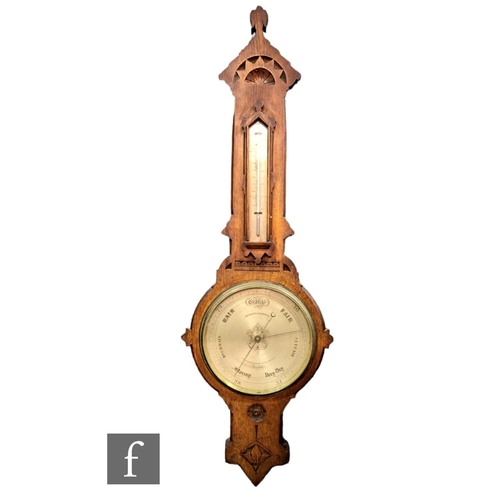 394 - A 19th Century Gothic cased oak barometer by Negretti & Zambra incorporating a thermometer over ... 