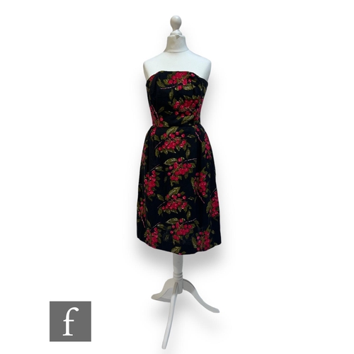 219 - A 1950s lady's vintage dress in black brocade with stylised pink berry and leaf motifs, with straple... 