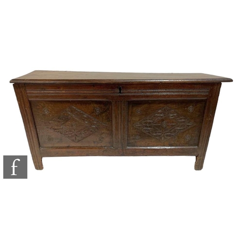 578 - An 18th Century oak coffer, the moulded edge over a carved lozenge two panel front on stiles, height... 