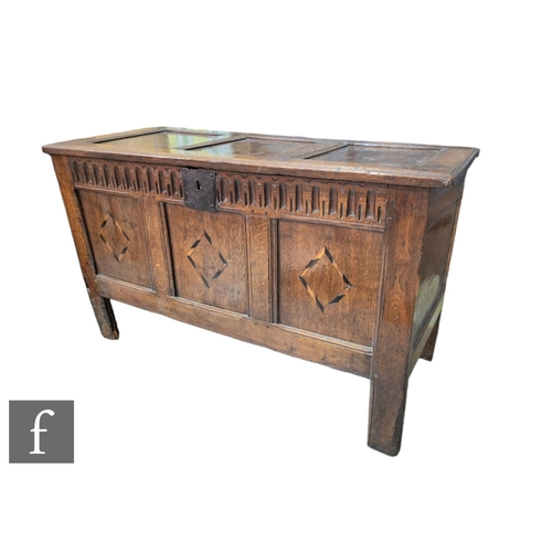 594 - An 18th Century oak coffer with triple panel hinged top over a conforming front with diamond chequer... 