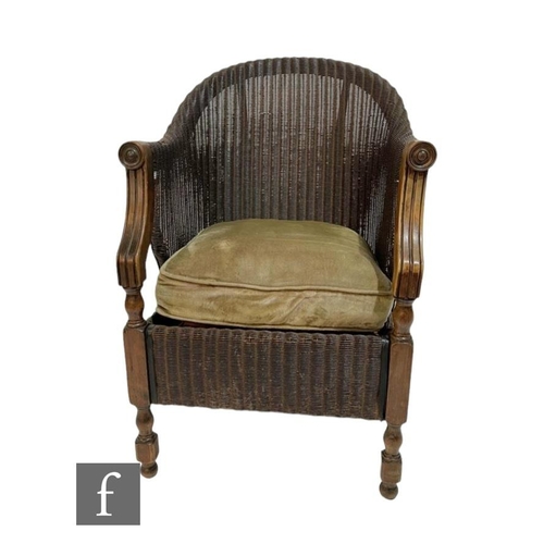 582 - A 1930s bergere style tub shaped easy chair, down swept arms and turned legs to the front.