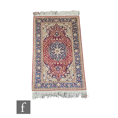 609 - A small late 20th Century Kashan rug, central red floral medallion on a ivory coloured ground within... 