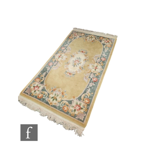 612 - A 1970s or later Chinese rug, pale ground flanked by a floral green border, 220cm x 124cm.