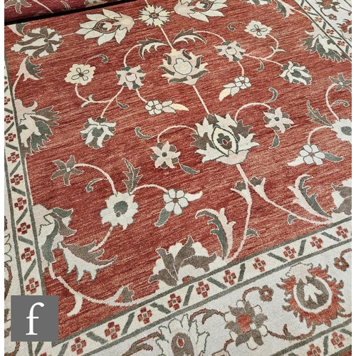 628 - A large Caucasian carpet all over floral decoration on an ivory and rust coloured ground, length 400... 