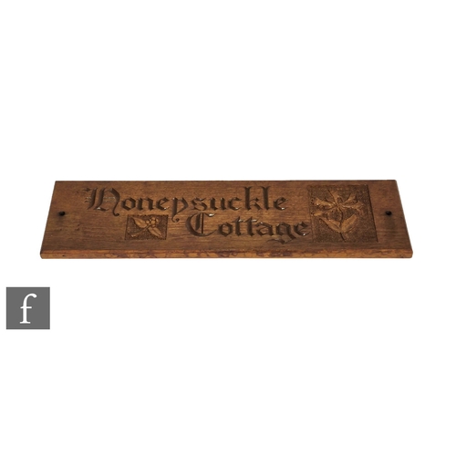 348 - A carved oak house name plaque 'Honey Suckle Cottage', 57cm x 15cm.