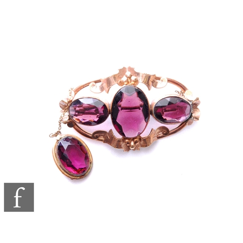 355 - A 9ct oval brooch set with three oval amethysts to a scroll border above a further drop amethyst, we... 