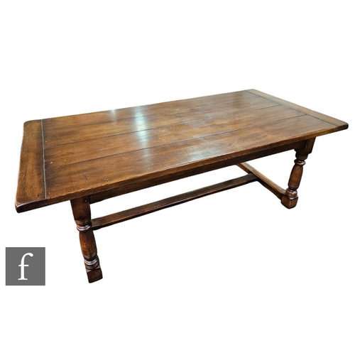 591 - A 17th Century style oak refectory dining table, the plank top over a plain frieze on turned legs un... 