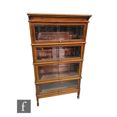 597 - An Edwardian mahogany four tiered sectional glazed bookcase, on square tapering legs, terminating on... 