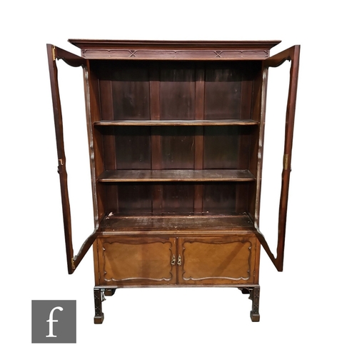 604 - An Edwardian Chippendale style mahogany display cabinet enclosed by a pair of glazed doors below a f... 