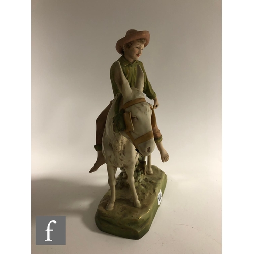 102 - A large late 19th to early 20th Century Royal Dux figure group modelled as a young boy riding a donk... 