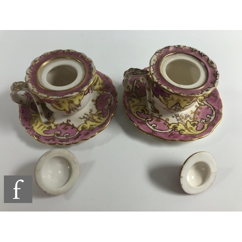 147 - A pair of 19th Century chamber sticks, each of waisted form with a domed cover and arched finial, mo... 