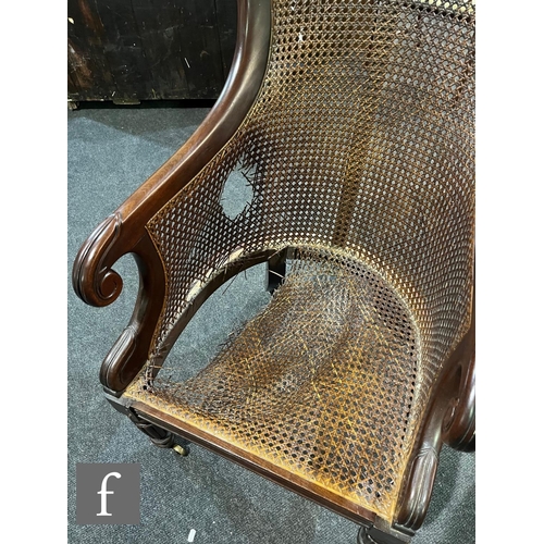 598 - A 19th Century mahogany bergere cane library chair in the manner of Gillows, the shaped bar back ove... 