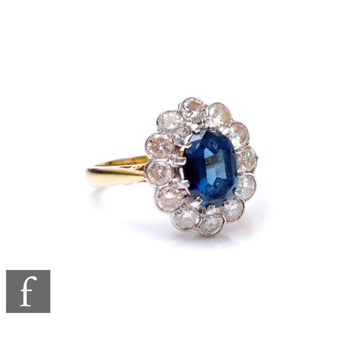 271 - An 18ct sapphire and diamond cluster ring, central oval sapphire, length 8.5mm, within a border of t... 