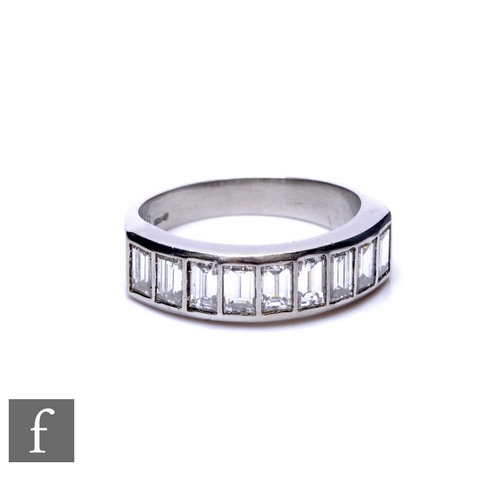 282 - A platinum diamond half eternity ring comprising nine channel set baguette stones, total weight appr... 