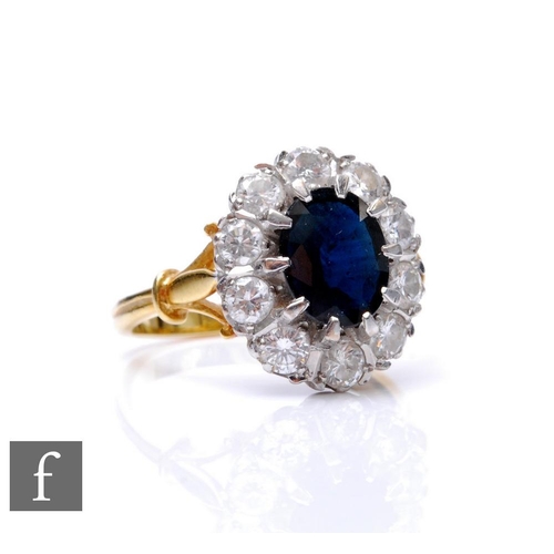 283 - An 18ct hallmarked sapphire and diamond cluster ring, central oval sapphire, length 9mm, within a bo... 