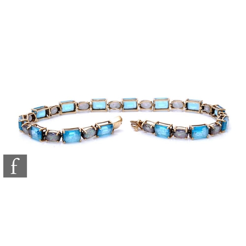 290 - A 9ct hallmarked blue topaz and faux alexandrite flexible bracelet comprising twenty eight alternati... 