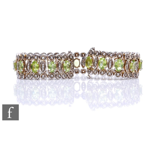 293 - A silver peridot and white sapphire flexible bracelet, twenty one marquise cut peridot spaced and wi... 