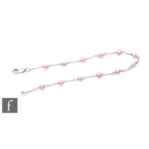 491 - An 18ct white gold bracelet detailed with twelve pink fresh water pearls, weight 2g, length 19cm, te... 