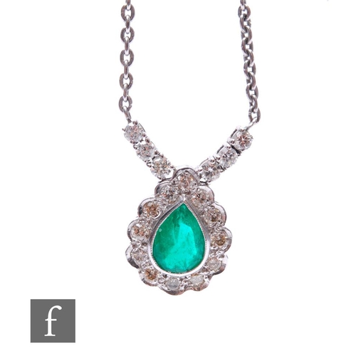 504 - An 18ct white gold emerald and diamond pendant, tear shaped emerald within a border of twelve brilli... 