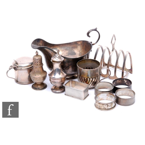 85 - Eleven items of hallmarked silver to include a toast rack, a sauce boat, two peppers, a small mug, f... 