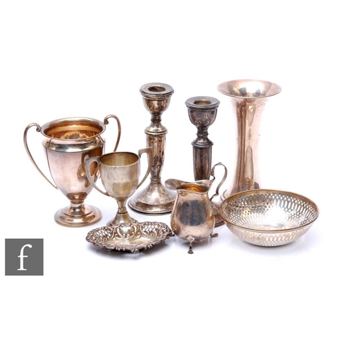 87 - A parcel lot of assorted hallmarked silver items to include two trophies, a cream jug, two bon bon d... 