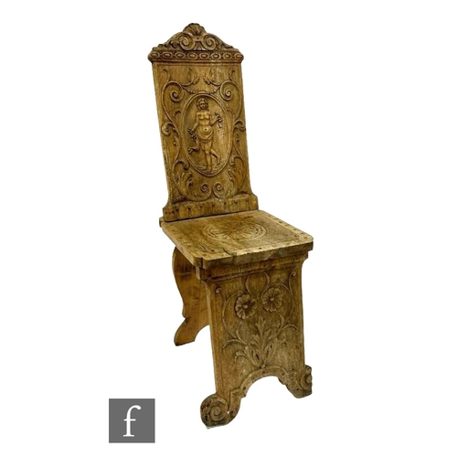 479 - A 19th Century Italian carved pine hall chair, the panelled back with an oval figure of a female bel... 