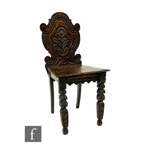 480 - A Victorian Black Forest style carved oak hall chair, the scroll back above a panel seat and fruit d... 