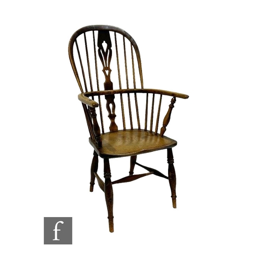 483 - A late 19th Century ash and elm seat Windsor elbow chair, on turned splayed legs and stretchers.