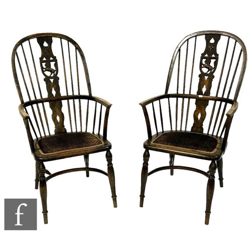 484 - A pair of early 20th Century beech Windsor elbow chairs, the central pierced splat with a rampant li... 