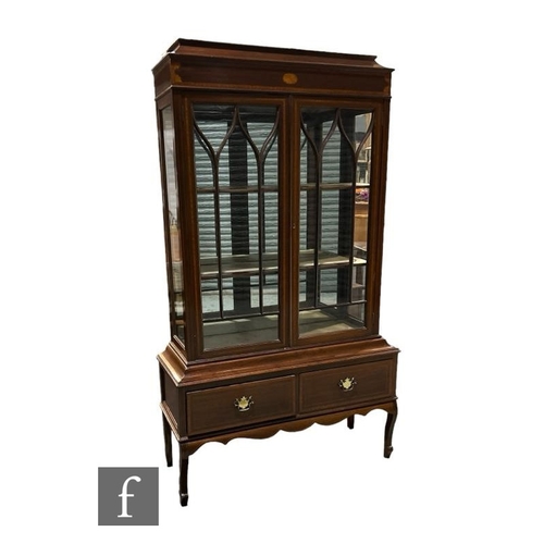 488 - An Edwardian satinwood crossbanded and inlaid mahogany display cabinet enclosed by a pair of arch ba... 