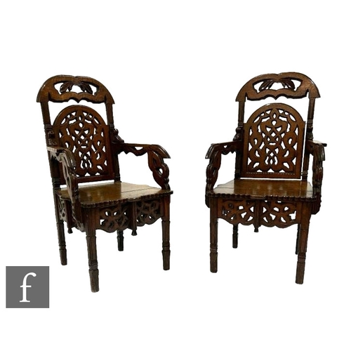 490 - A pair of late 19th Century carved oak ecclesiastical style hall chairs, with pierced arch backs ove... 