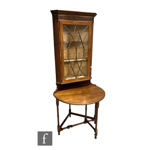 509 - An Edwardian mahogany floorstanding corner cupboard/table enclosed by a pair of bar glazed doors bel... 