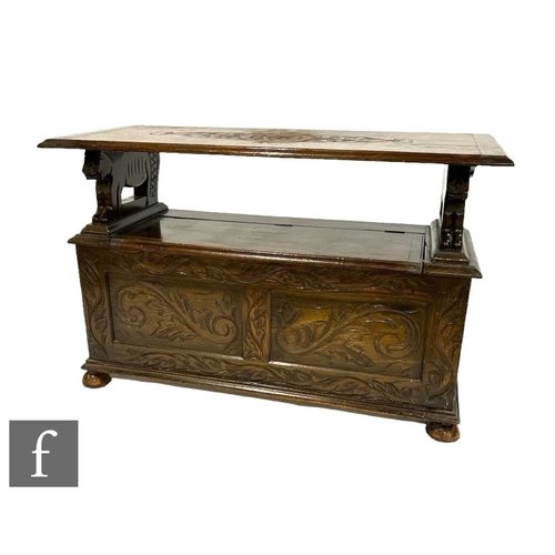 518 - A Victorian style carved oak monk's bench, fold over top above a scroll decorated front, on ball fee... 