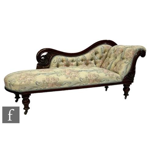 519 - A Victorian carved rosewood scroll and buttoned back chaise longue on turned feet, in pale floral de... 