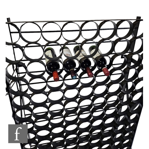 526 - A large one hundred and sixty two bottle wine rack, the black painted metal frame with circular wine... 