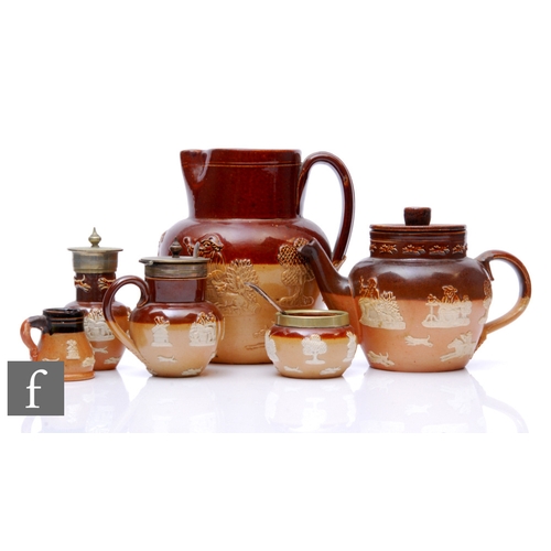 128 - A collection of Doulton lambeth 'Harvest Wares' to include a three piece cruet, a small teapot, a mi... 