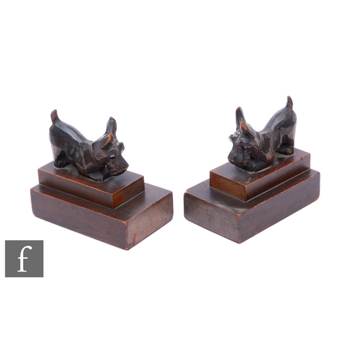 194 - A pair of 1930s carved walnut Scottie dog bookends, each with glass inset eyes, on stepped bases, wi... 