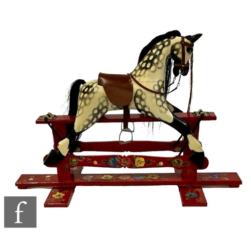 214 - A late 20th Century painted pine rocking horse finished in a dappled grey finish, made by Roundhouse... 