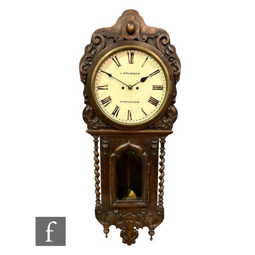 307 - A Victorian carved oak wall clock by L Brunner Birmingham, circular dial over an arched glazed door,... 