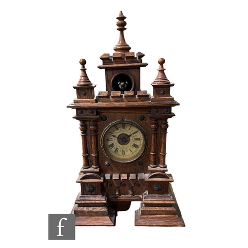 311 - A 19th Century walnut cased cuckoo mantle clock of castellated and turned finial form, circular Arab... 