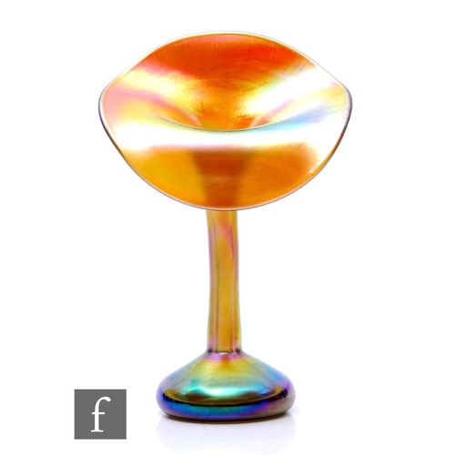 An early 20th Century Louis Comfort Tiffany Favrille glass vase, the compressed ovoid base with a tall slender stem neck with a wide Jack in the Pulpit style rim, decorated with a bright gold petrol iridescence, engraved signature, height 24cm.
