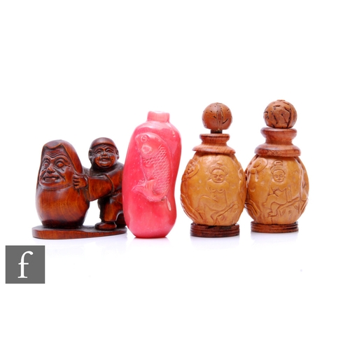 263 - A 20th Century Chinese pink hardstone snuff bottle decorated with a carved fish, a wooden netsuke of... 