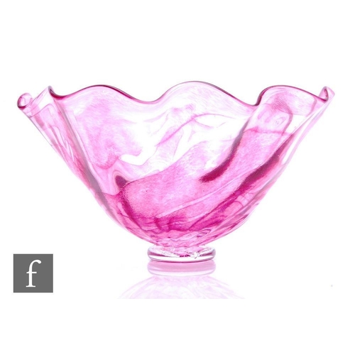 929 - A later 20th Century studio glass bowl, the wave rim body decorated with a mottled pink random strap... 