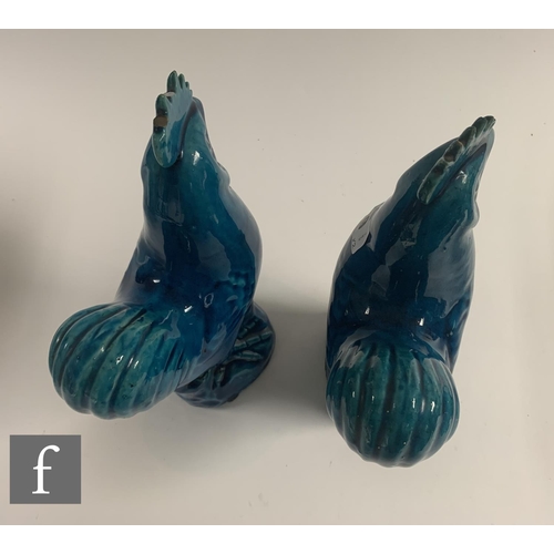 9 - Two late Qing Dynasty Chinese Sancai glazed cockerels, each moulded and raised on rocky outcrop base... 