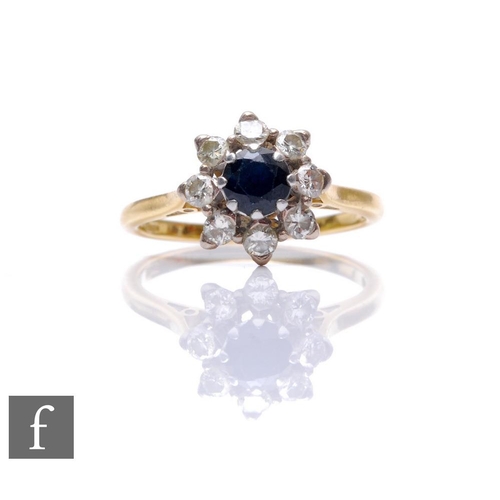 103 - An 18ct hallmarked sapphire and diamond cluster ring, central sapphire within an eight stone brillia... 