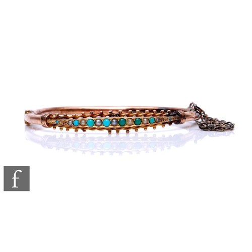 128 - An early 20th Century 9ct hinged bangle set with alternating graduating seed pearls and turquoise, w... 